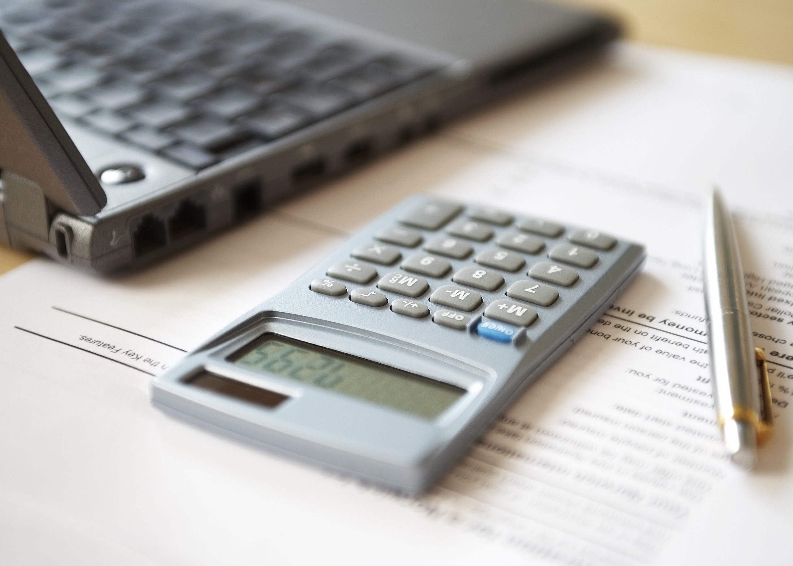 Image of a calculator, pen, paperwork, and laptop. Link takes you to the Bank of Versailles Certificates of Deposit page.