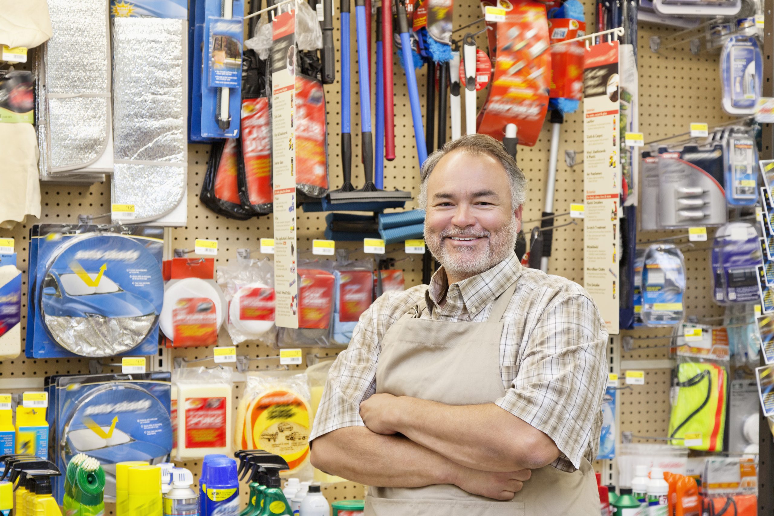 Business owner smiling in front of merchandise.